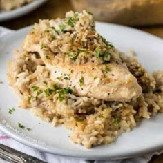 chicken and rice casserole on a white plate with silverware next to it