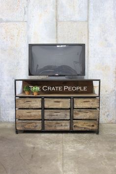 the crate people logo is displayed on an old tv stand with drawers and a plant in it