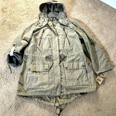 Nwt Levi's Plus 1x Grey Hooded Anorak Jacket Grey In Color (Shown On Tag) Anorak/Parachute Style Plus Ladies 1x Light/Medium Weight Removable Hood Drawstring Clinch Waist Many Button And Zipper Pockets 33" Long In Back 31" Long In Front Pit To Put Approx 24" Zipper And Button Closure 3/4 Length Sleeve Option With Button On Sleeve Great Coat For Anytime! Smoke And Pet Free All Sales Final Hooded Fall Windbreaker With Cargo Pockets, Spring Hooded Parka With Cargo Pockets, Weatherproof Hooded Utility Jacket For Cold Weather, Casual Khaki Parka With Detachable Hood, Khaki Hooded Outerwear With Cargo Pockets, Utility Outerwear With Drawstring Hood For Outdoor, Utility Weatherproof Hooded Jacket For Fall, Utility Fall Windbreaker With Adjustable Hood, Utility Fall Weatherproof Hooded Jacket