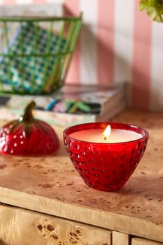 a red candle sitting on top of a wooden table