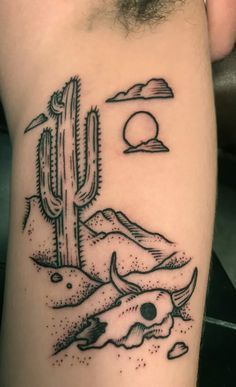 a black and white photo of a cactus with mountains in the background on a man's arm