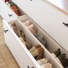 an open drawer filled with shoes on top of a wooden floor