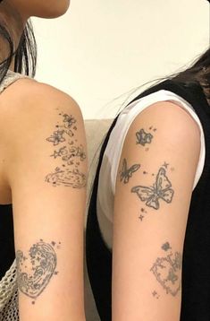 two women with tattoos on their arms