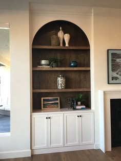 a living room with a fireplace and built in bookshelves