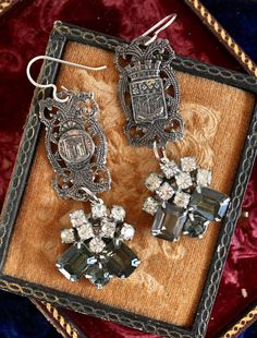 The elaborate Paris components in these gorgeous earrings are salvaged from an antique France souvenir bracelet. The rhinestone drops are from a pair of mid 1900s earrings, and are a rich olive green and clear rhinestone combination. These are so beautiful with just about anything you would wear by they do make an elegant statement with a formal dress. They would also dress up your favorite jeans and a crisp, white blouse. They are just over two inches long without the ear wires. Paris Notre Dame, Red Rhinestone Earrings, Evening In Paris, Falmouth, Vintage Souvenir, Red Rhinestone, Earrings Vintage, Rhinestone Earrings, Gorgeous Earrings