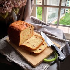 a loaf of bread sitting on top of a wooden cutting board next to a knife