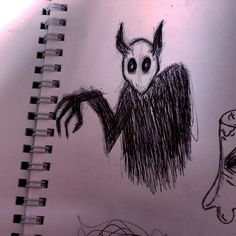 a drawing of an evil looking creature on a notebook