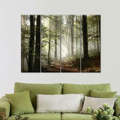 a living room with green couches and paintings on the wall in it's center