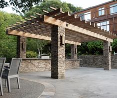 an outdoor dining area with stone walls and pergolated roof