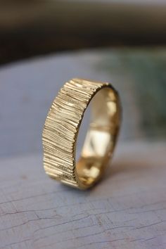 a gold wedding ring sitting on top of a table