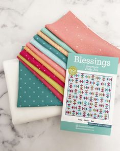 a stack of quilting supplies sitting on top of a marble counter next to each other