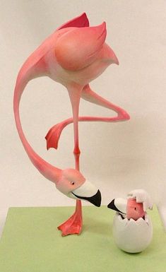 a pink flamingo standing next to an egg