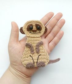 a hand holding a small crocheted stuffed animal