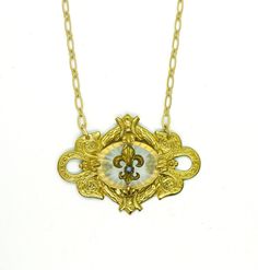 "This amazing one of a kind necklace is a beauty!! This unique piece is handmade featuring a 1940s oval camphor glass I've created a setting for. In the center there are 4 prongs holding the glass in, and then front & center is a Victorian era gold Fleur de Lys with a round piece of turquoise in it. The Fleur de Lys was taken from a 100 year old stickpin I manipulated into a focal point. There is a 18\" matte gold plated chain on this piece with a 3 1/2\" extender chain. Truly unique, truly beau Bohemian Medallion Necklace From Vintage Collection, Antique Gold Medallion Necklace With Vintage Charm, Handmade Antique Medallion Necklace With Round Pendant, Handmade Antique Round Medallion Necklace, Vintage Brass Long Necklace With Charm, Ornate Vintage Charm Necklace As Gift, Ornate Vintage Charm Necklace For Gift, Vintage Brass Long Necklace, Antique Handmade Medallion Necklace Gift