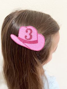 "Cowboy Birthday bow for Cowgirl/Western theme birthday party! Cowboy Hat Bow is slightly over 3\".   Cowboy hat detail is made with heat sealed felt and pink/fuchsia glitter vinyl or brown/red and gold glitter vinyl with custom number. Alligator Clip with teeth attached. Safety- hair accessories are not a toy, please do not leave children unattended/with hair bows as they are handmade and may contain small parts." Novelty Pink Mini Hat For Birthday, Pink Novelty Mini Hat For Birthday, Customizable Pink Birthday Hat, Birthday Hair Bow, Western Birthday Party, Pink Cowboy, Western Birthday, Cowgirl Birthday, Chapeau Cowboy