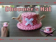 a crocheted pink hat with angel wings and a star on the top, sitting on a table