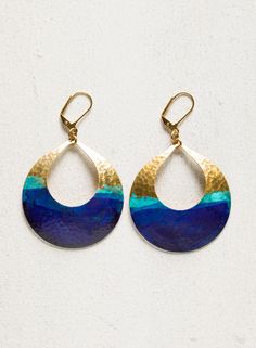 Hammered brass hoops are accented with a natural verdigris patina and splashed with indigo pigment. Gold-plated leverbacks. Nickel and lead free.2.5“ [6.25 cm] long. Hand Forged Blue Round Earrings, Artsy Blue Metal Jewelry, Blue Hoop Brass Jewelry, Blue Brass Hoop Jewelry, Blue Teardrop Earrings With Patina, Blue Brass Hoop Earrings, Artisan Blue Earrings With Oxidized Finish, Blue Artisan Earrings With Oxidized Finish, Blue Hand Forged Bohemian Earrings