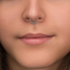 a woman with a nose piercing in the shape of a ring on her left side