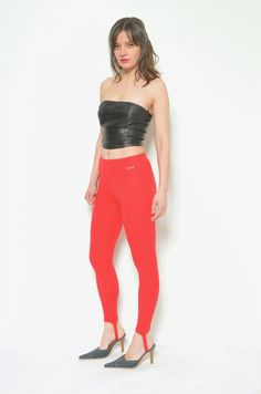 "These vintage 80s stirrup pants are a fun and funky pair of high waisted red leggings that will make you stand out from the crowd. They are made of stretchy polyester blend fabric that hugs your body and feels smooth on your skin. The pants feature a stirrup design that hooks under your feet, creating a sleek and seamless look. They have an elastic waistband that ensures a comfortable fit. These pants are great for layering, dancing, or lounging. They are in very good condition, with no stains, tears, or holes. They are a size small, with the following measurements: - Label: Wings (made in Holland) - Era: 1980's - Color: red - Fabric: 100%  poliamid  - Condition: very good. Ready to wear. - Tag Size: 36 - Fits size: small MEASUREMENTS: Waist: 23\" (60 cm) elastic Length: 32\"(81 cm) Model Stirrup Pants, Pants High Waisted, Womens Trousers, Red Leggings, Stirrups, Red Fabric, Trousers Women, Capri Pants, Dancing