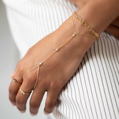 This hand chain features cubic zirconia stones in a bezel setting to add sparkle. Wear alone or pair with the matching ring for a beautiful and delicate look. Gold Vermeil White Zirconia Crystals Crystals 3mm Crystal chain section length 4in(10cm) Wrist Length:6-7.5in(15-19cm) Handcrafted in NYC #B301 Dainty Hand Set Diamond Jewelry, Dainty Hand-set Diamond Jewelry, Dainty Chain Body Jewelry For Wedding, Elegant Adjustable Jeweled Body Jewelry, Adjustable Diamond Jewelry With Sparkling Stones, Elegant Gold Body Jewelry With Cubic Zirconia, Elegant Cubic Zirconia Chain Ring Gift, Elegant Chain Rings For Parties, Diamond White Jeweled Cubic Zirconia Jewelry