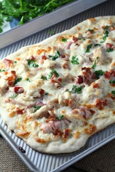 a pizza sitting on top of a pan covered in cheese and toppings with meat