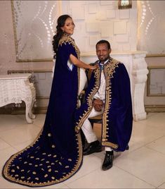 a man and woman dressed in traditional african clothing pose for a photo together on the dance floor