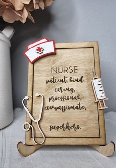 a wooden sign that says nurse next to a vase with flowers and a stethoscope