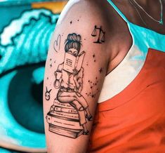 a woman with a tattoo on her arm holding a book and sitting on top of a stack of books