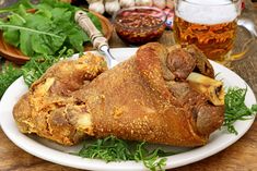 a large piece of meat sitting on top of a white plate next to some vegetables