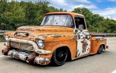 an old rusted truck is parked on the side of the road