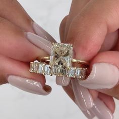 a woman's hands holding two engagement rings