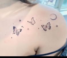 the back of a woman's shoulder with three butterflies flying in the night sky