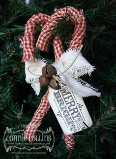 an ornament hanging from a christmas tree decorated with candy canes and twine