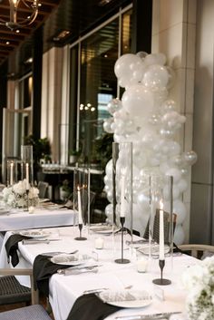 the table is set with white balloons and silverware