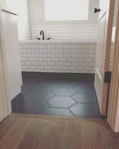 an open door leading to a bathroom with black and white tile