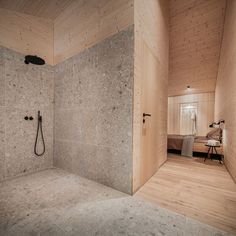 a bathroom with a walk in shower sitting next to a wooden wall and flooring