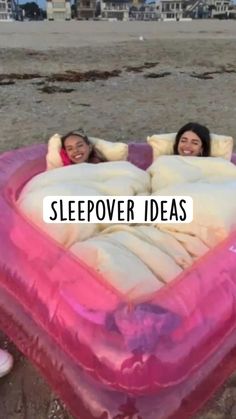 two women laying in an inflatable heart shaped bed with the words sleepover ideas