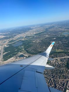 the wing of an airplane flying over a city