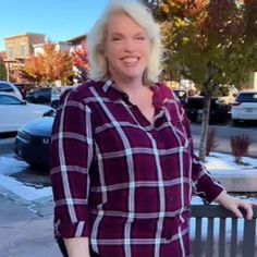 a woman standing next to a wooden bench