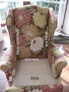 an upholstered chair with flowers on it in front of a window and a sign that says, there is no place for you to sit