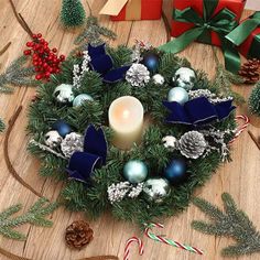 a christmas wreath with candles and ornaments on a table