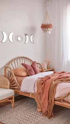 a bedroom with wicker furniture and moon phases hanging on the wall above the bed