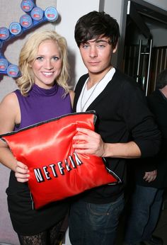 a young man and woman holding a red bag