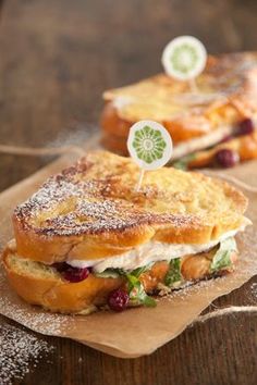 two sandwiches sitting on top of brown paper