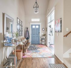 a hallway with a blue door and some pictures on the wall next to a wooden floor