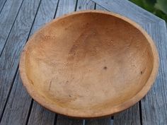 a wooden bowl sitting on top of a wooden table