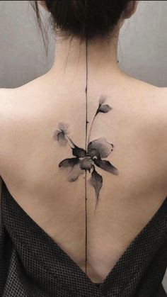 the back of a woman's neck with flowers tattooed on her upper and lower back