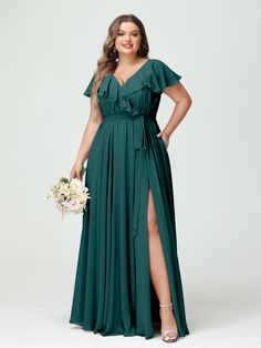 a woman in a long green dress is posing for the camera with her hands on her hips