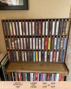 a book shelf filled with lots of books on top of a hard wood floor next to a wall