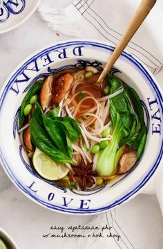 a white and blue bowl filled with soup next to chopsticks on a table